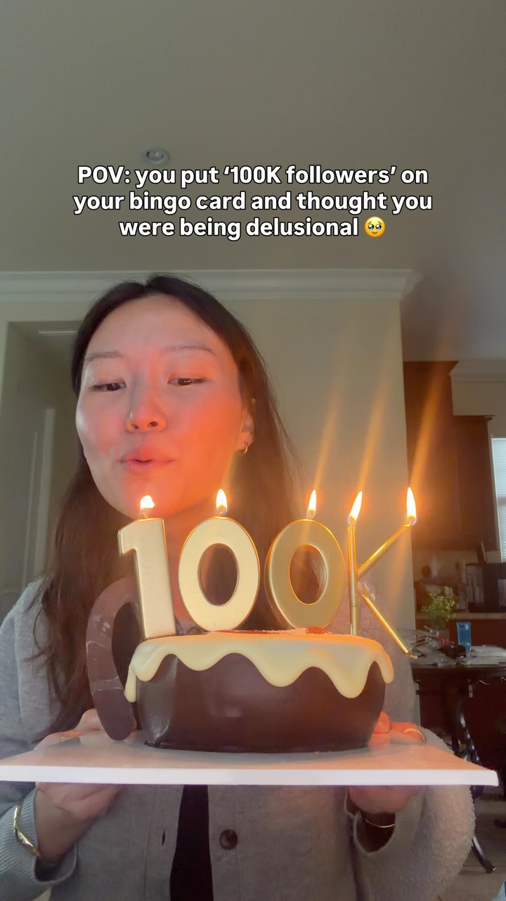 Melanie holding a cake with 100K candles